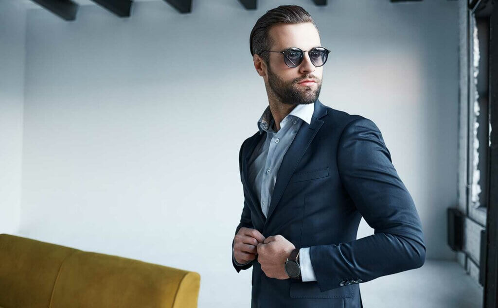 Aspecto profesional con apariencia informal de negocios hombre de negocios  que elige una chaqueta de traje para un código de vestimenta informal hombre  barbudo que se viste para un evento informal de