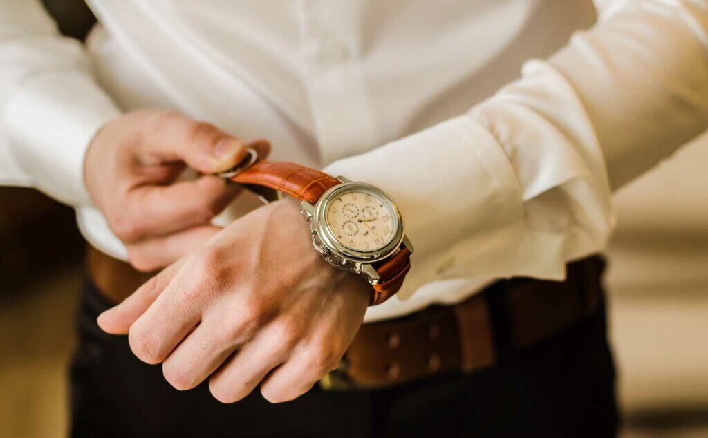 Hombre camisa poniendose reloj