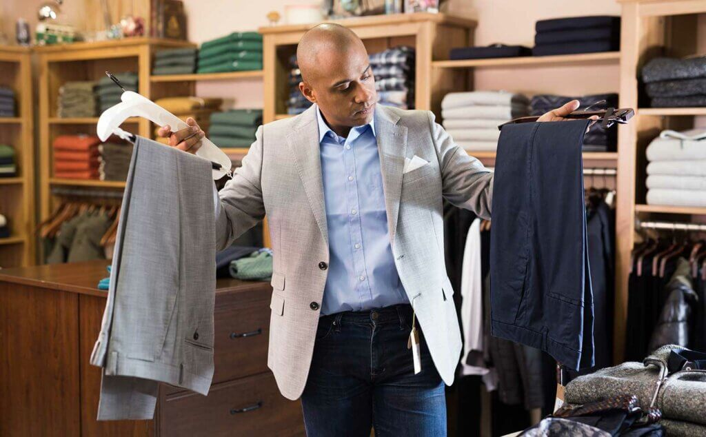 Hombre eligiendo traje tienda ropa