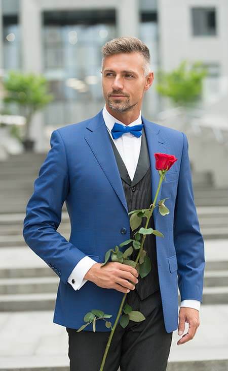 Hombre traje azul llevando rosa