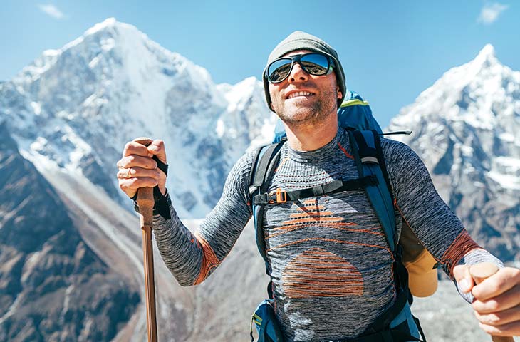 Hombre sonriendo trekking montana gafas sol