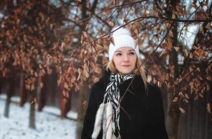 Mujer abrigo negro gorro punto nieve