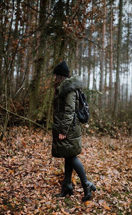 Mujer caminando bosque hojas