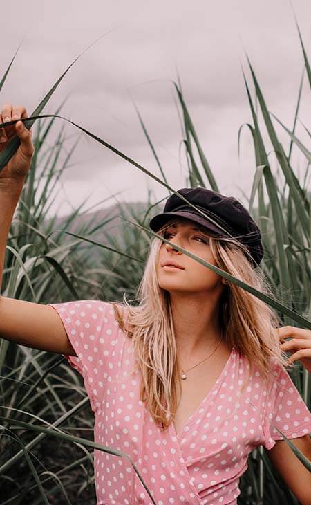 Mujer camisa rosa gorra negra campo