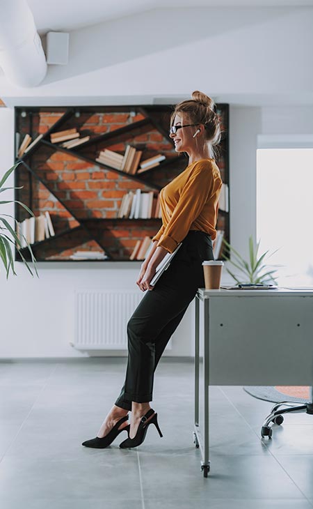 Mujer de negocios de pie cerca mesa oficina