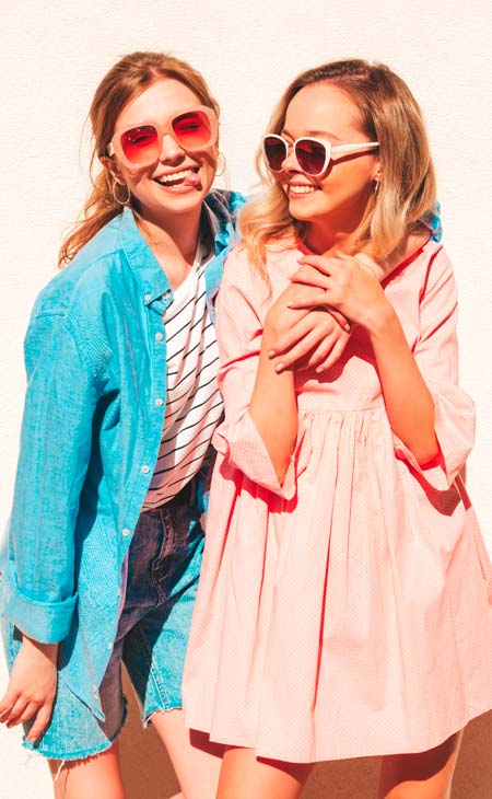 Dos chicas jovenes soriendo con gafas de sol