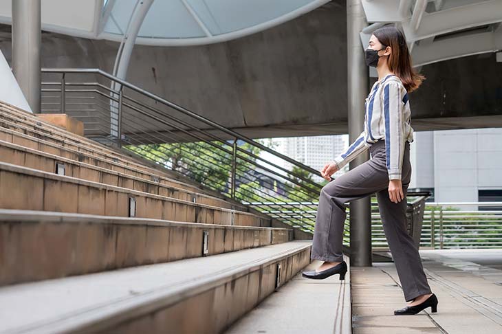 Mujer elegante trabajadora subiendo escaleras