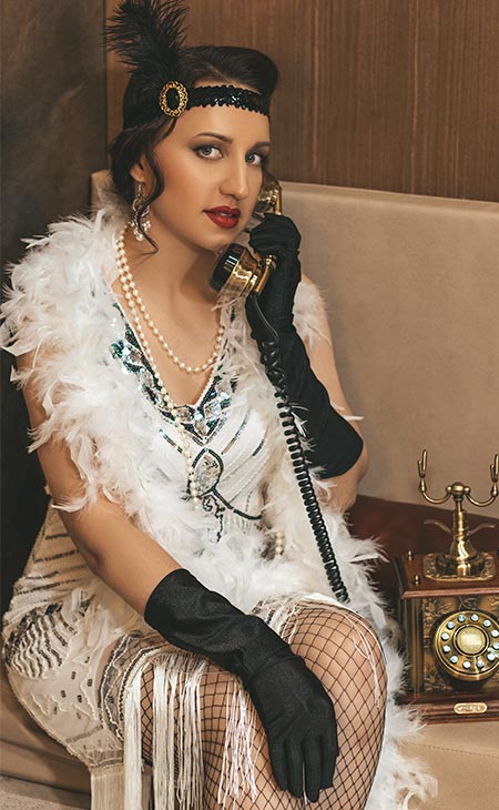 Mujer 1920s hablando telefono vestido plumas blanco